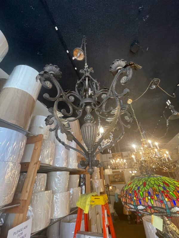 Vintage wrought iron chandelier hanging from ceiling