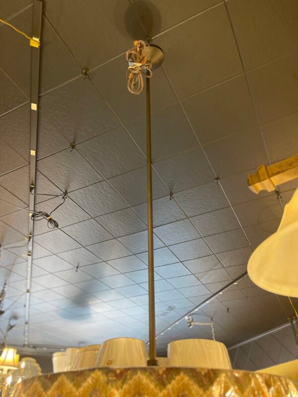 Fabric-wrapped zigzag shade with bronze suspension rod