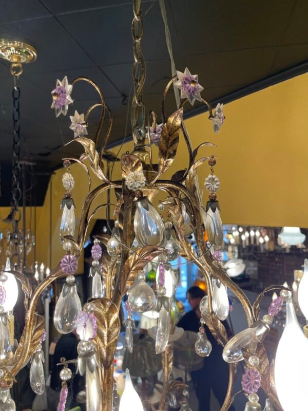 Floral detail on top of gold chandelier with lavender crystals