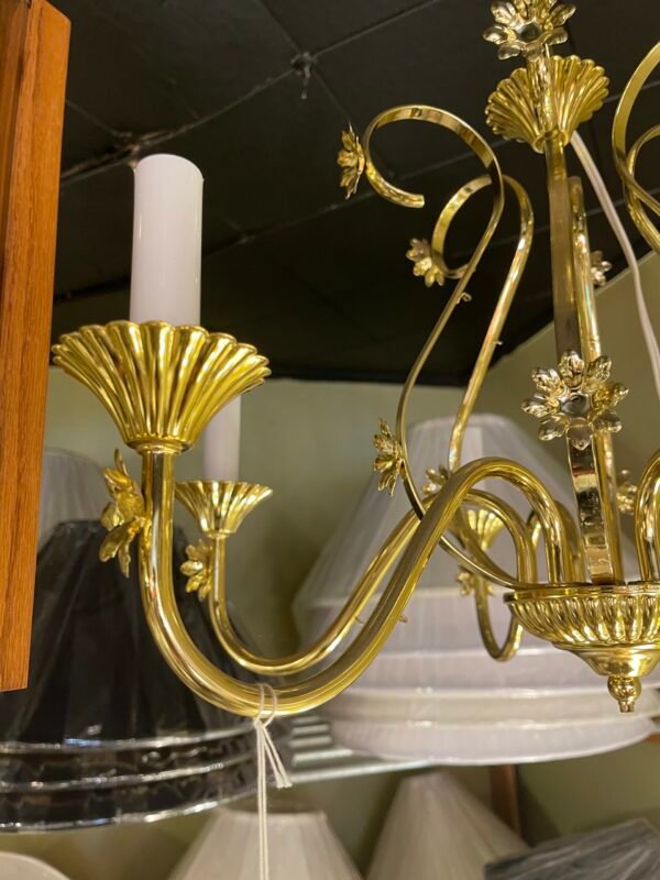 Close-up of curved brass arm with scalloped bobeche