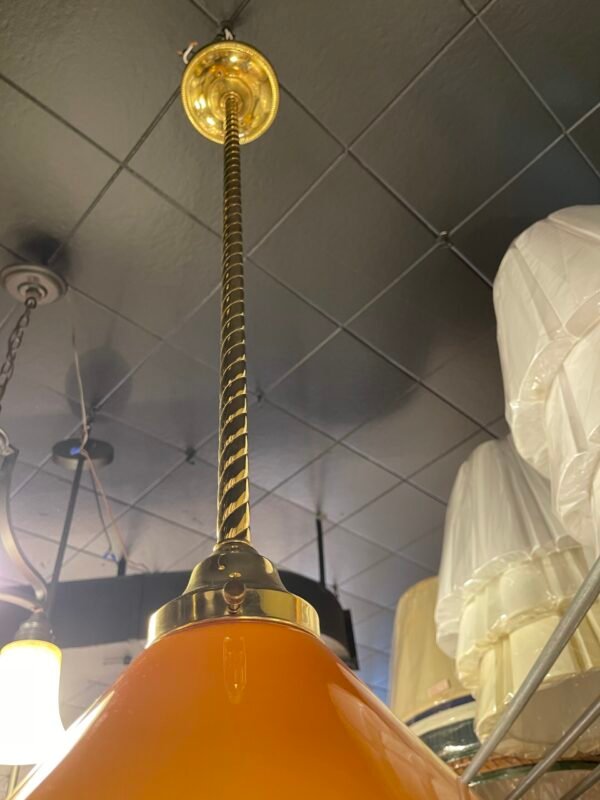 "Cone-shaped amber glass shade with brass rod"